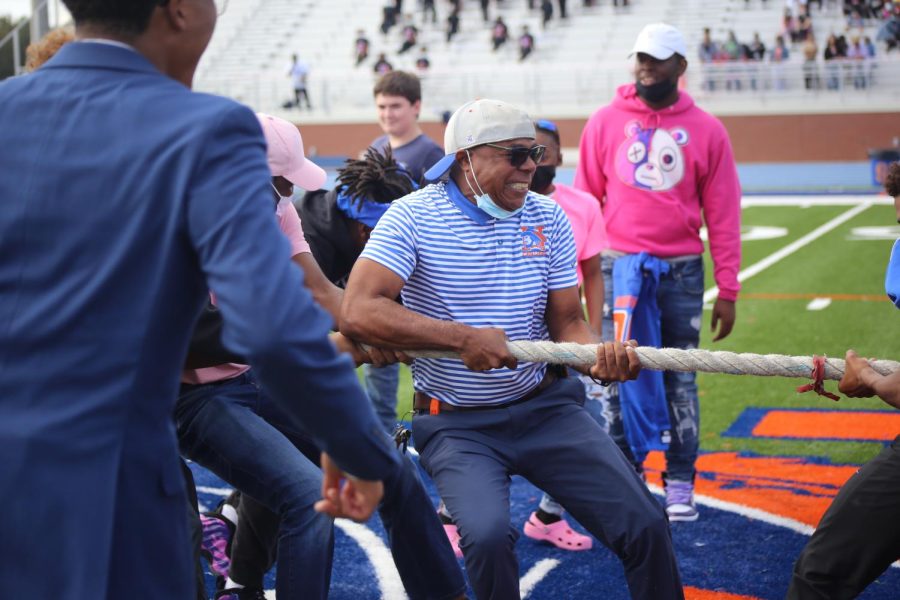Administrator Terrance Alridge pulls for his team during a tug-of-war game. Student government organized RNEs first outside pep rally during the 2021-2022 school year. 