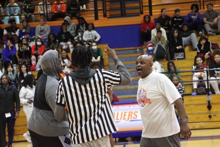 Coach Walter Wilson (right) and junior MarkQuelle Moser argue with the referee before the tip off. The teacher side won the first possession.  