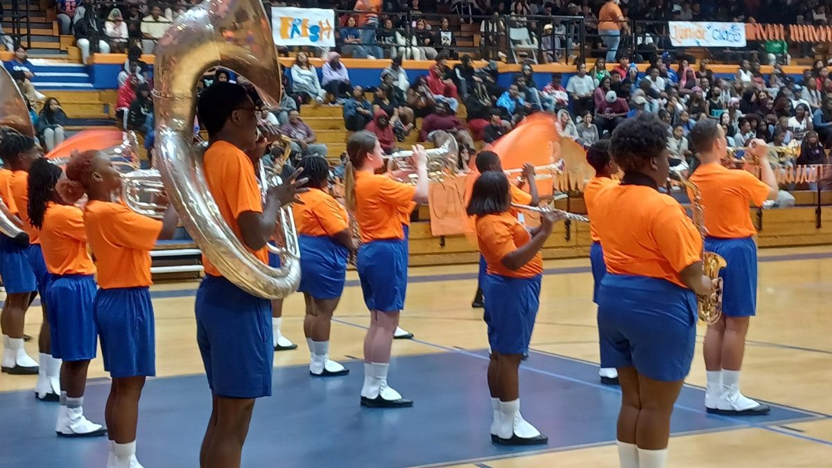 The band proceeds the pep rally with a song.