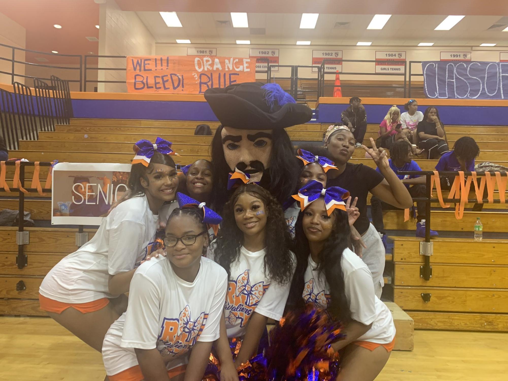 Cheerleaders take a photo with the Cavalier. 