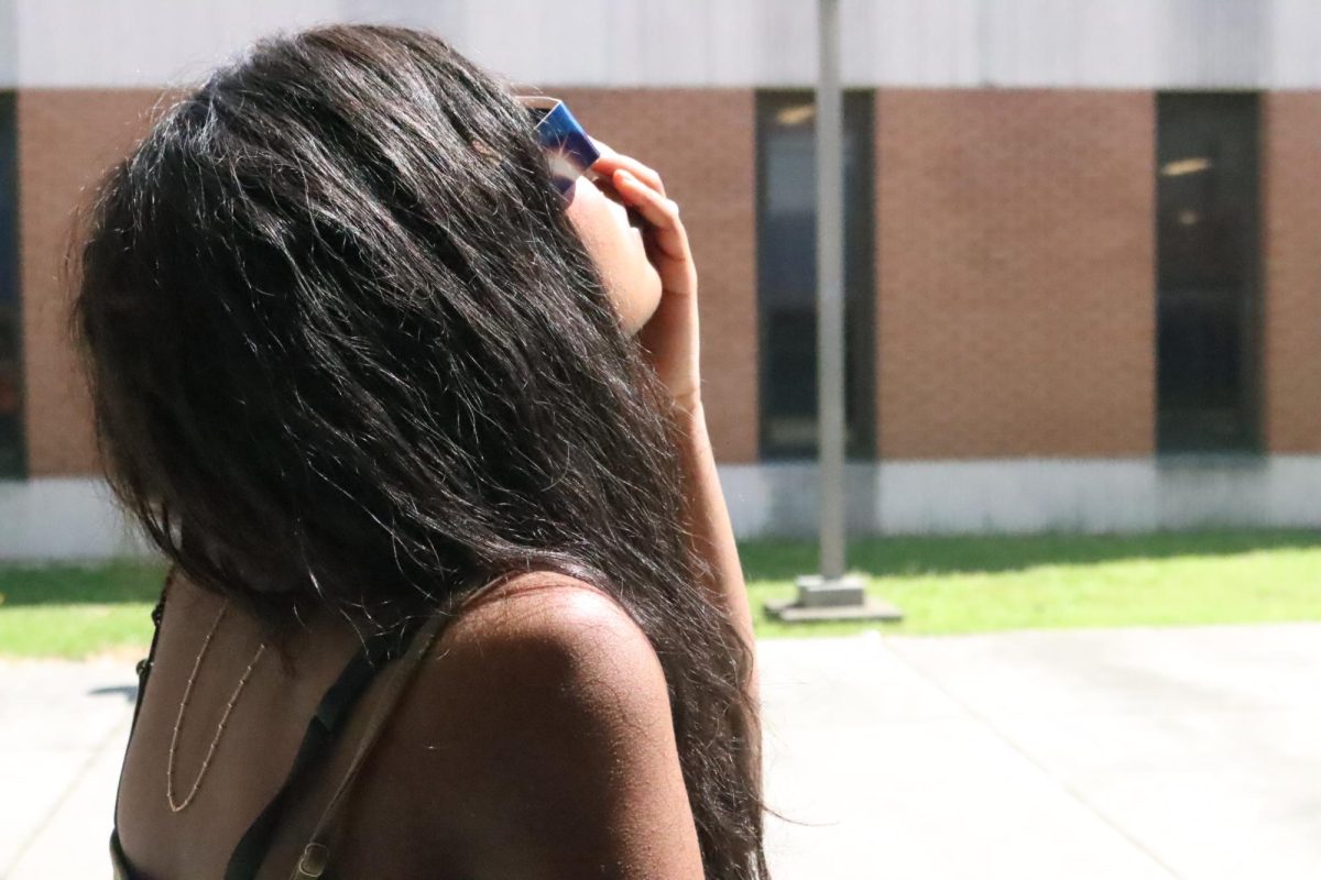 Sophomore Rihanna Williams watches the partial eclipse. The eclipse is very cool. Its interesting to look at.