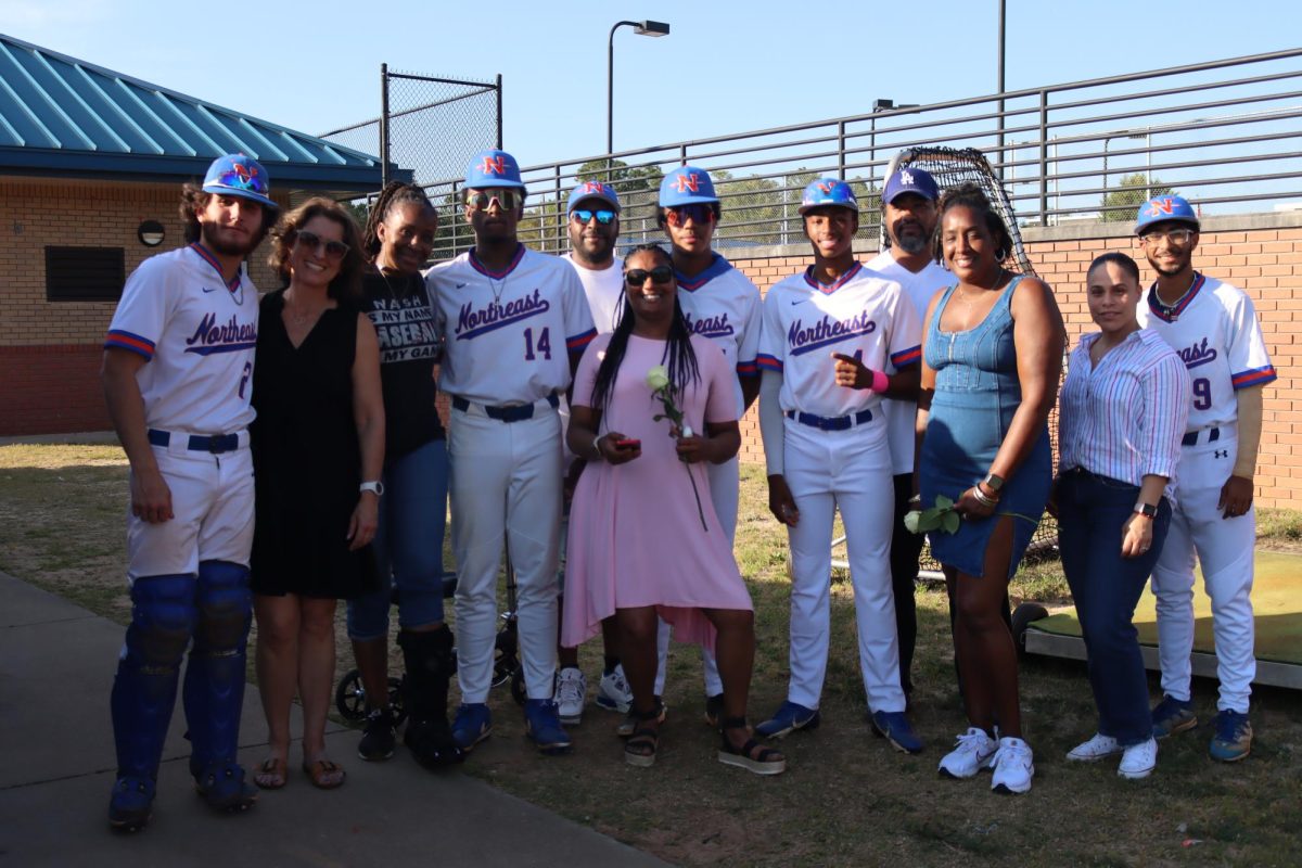 Seniors and family pose for a group photo post senior night. 