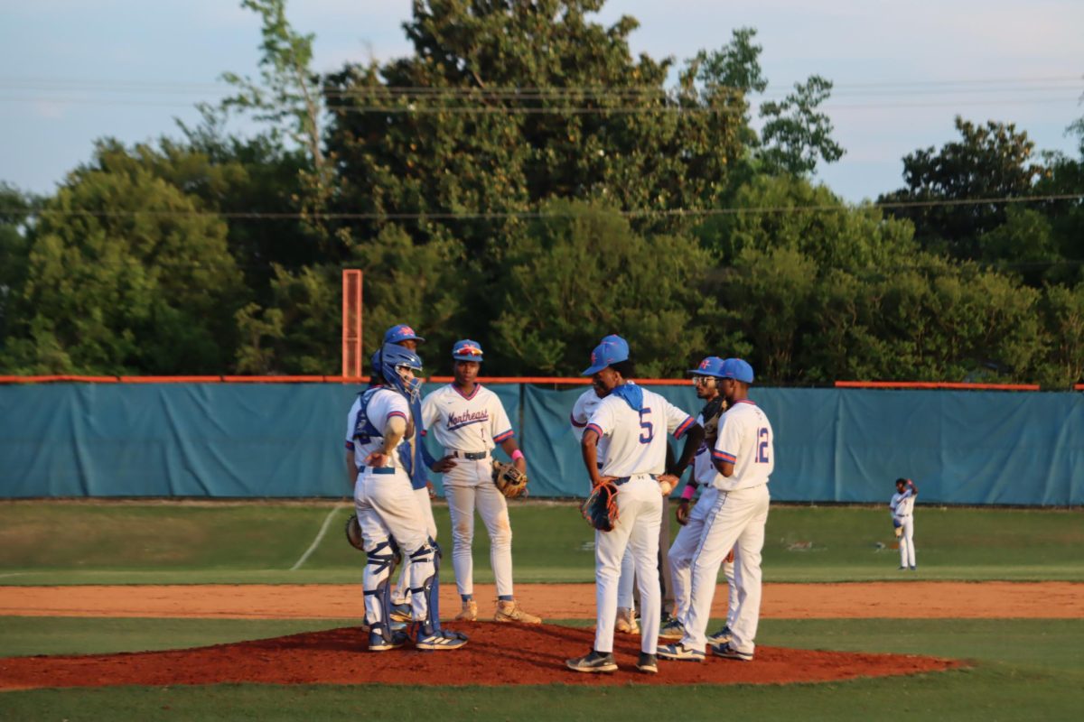 Players do mid-game huddle while referees decide call. 