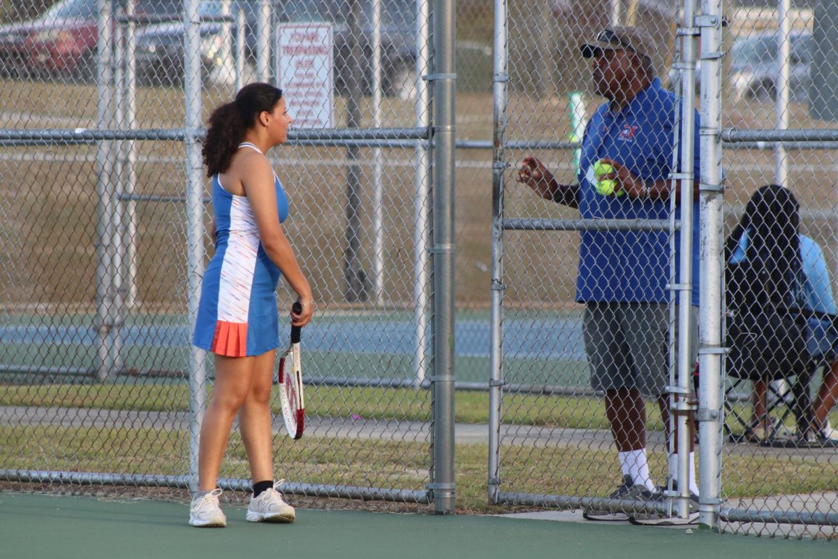 Coach Domino Boulware gives Senior Dulce Calix-Echeverria feedback.