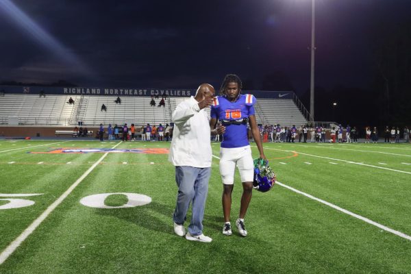 Senior Demarcus Haliburton and Coach Wilson exchange a handshake after his senior walk.