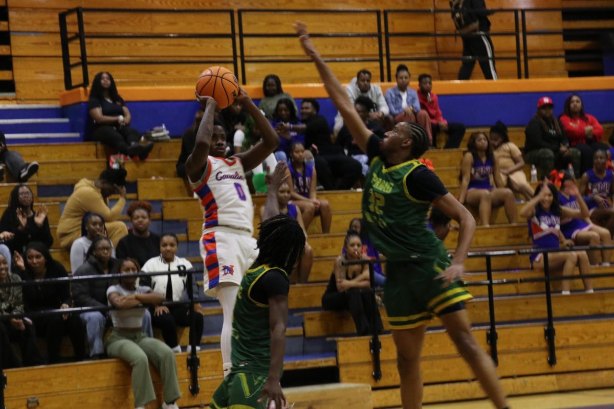 Senior Leslie Kennedy shoots a three while an opponent attempts to block him.