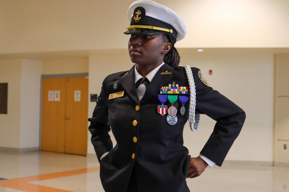 Ensign Officer Jayda Bridgett hands out pins to fellow officers during their promotion.
