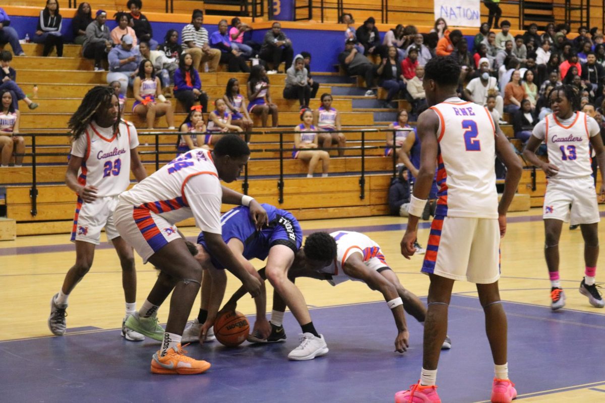 Freshman Eian Adams, junior Christopher Asuzu and senior Emmanuel Ard dive for the ball on defense. 