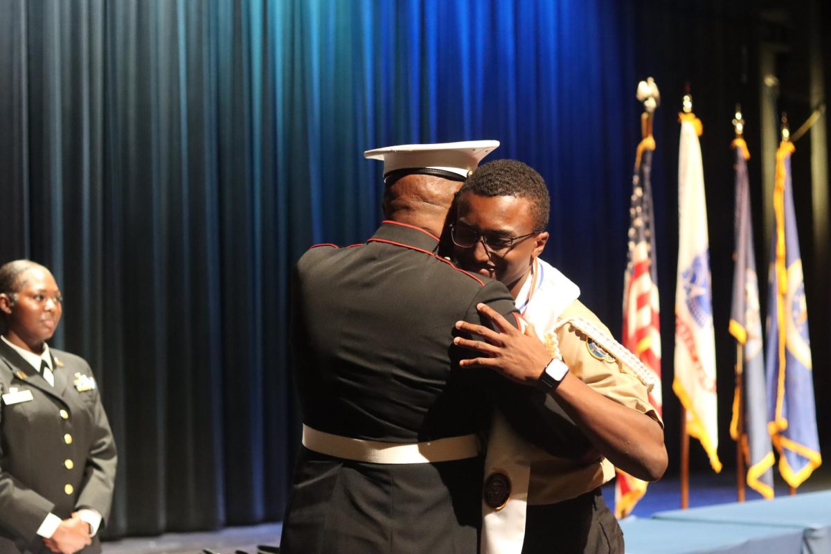Senior Shameke Jones embraces Master Gunnery Sergeant Frederick Gaston.