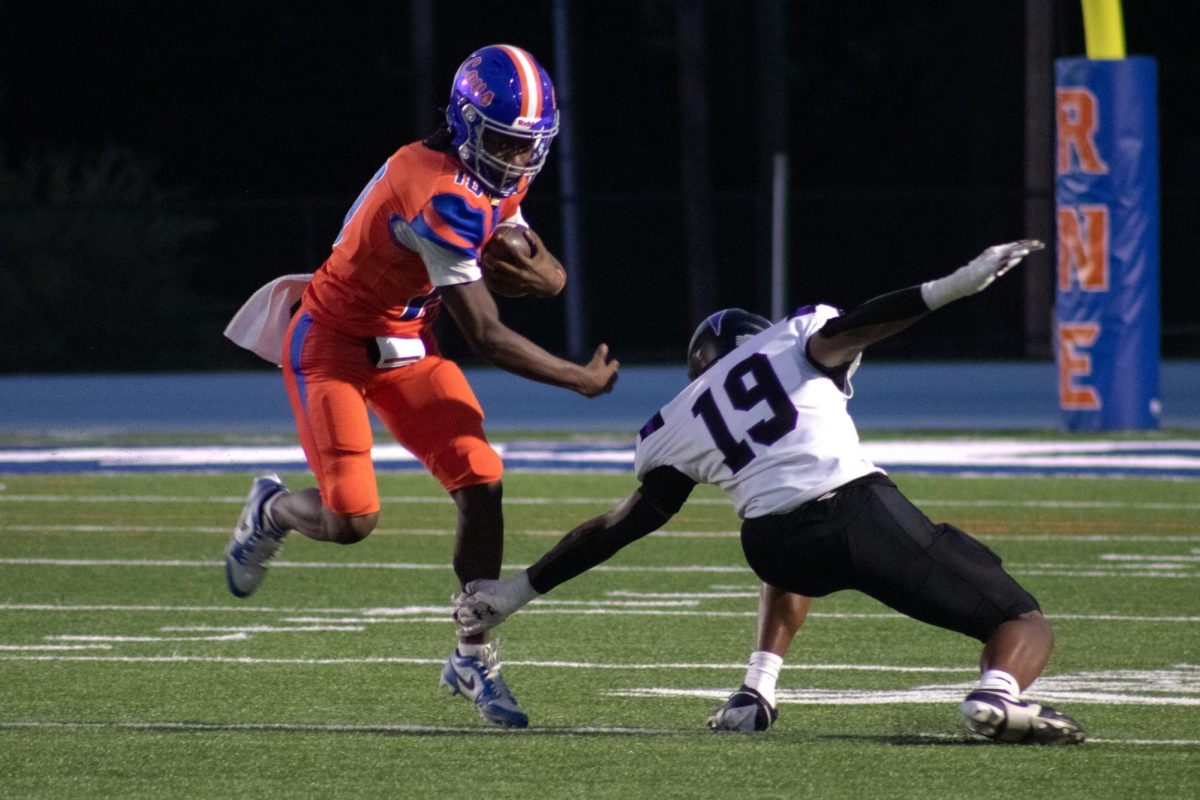 Senior Kemarion Willingham avoids a tackle as he runs the ball.