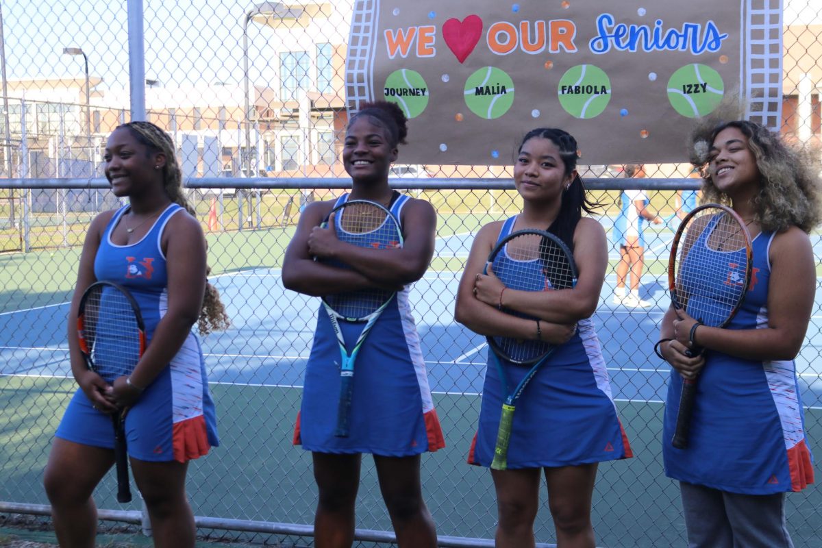 Seniors Journey Schofield, Malia Johnson, Fabiola Gutierrez-Morente and Isabella Rueger pose below the senior banner.