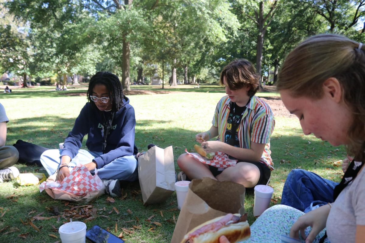 Juniors Logan Jones and Sydnee Turner eat lunch with senior Baye Lewis on the Horseshoe.