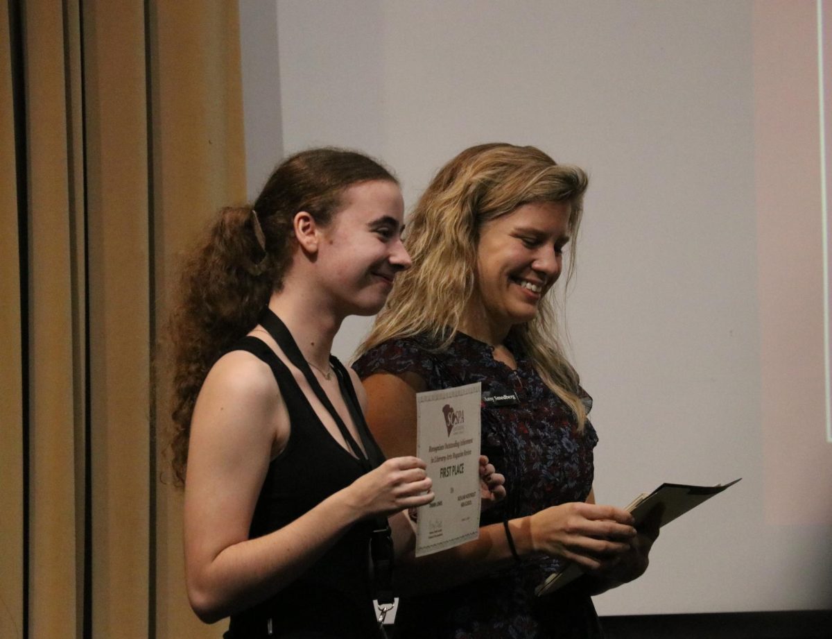 Senior Tinnin Lewis poses for a picture with her first place award for literary magazine review.
