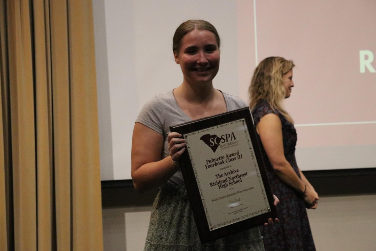 Senior Baye Lewis smiles while walking back to the group with Palmetto Award for Class III.
