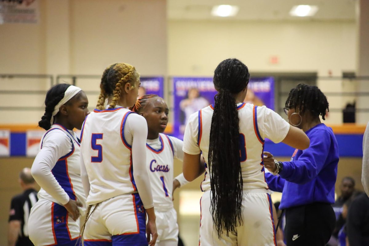 The girls basketball team huddles together.

El equipo de baloncesto femenino se reúne en círculo.