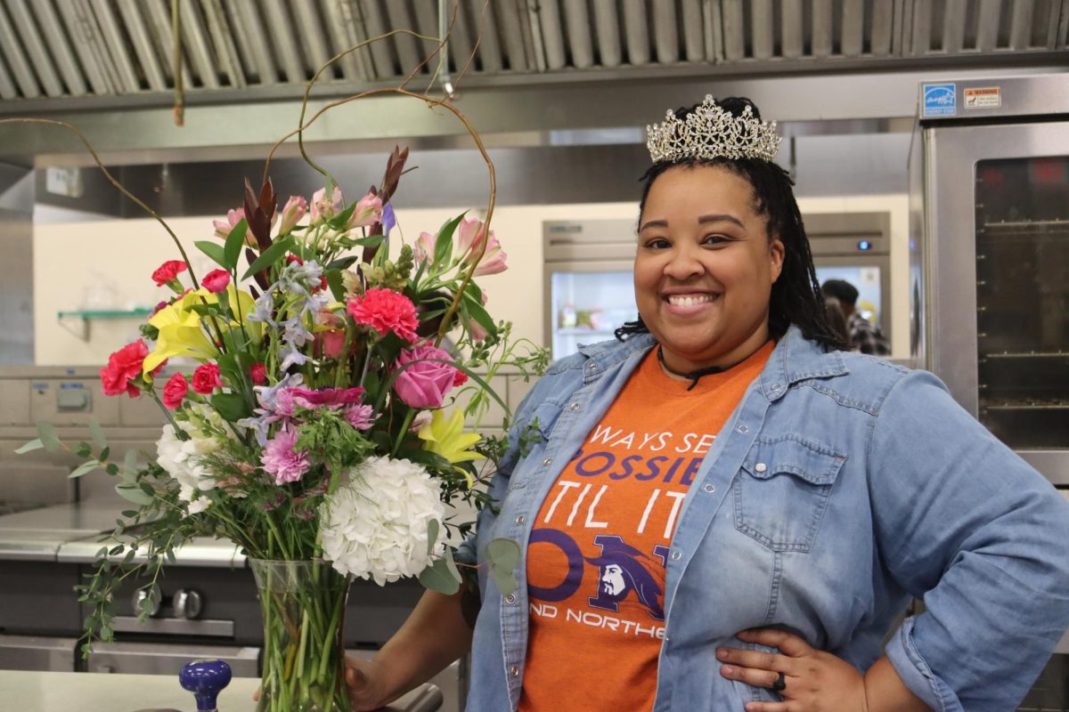 Chef Aris Wrightson poses with a crown and a bouquet of flowers after being named 2026-2027 Teacher of the Year.