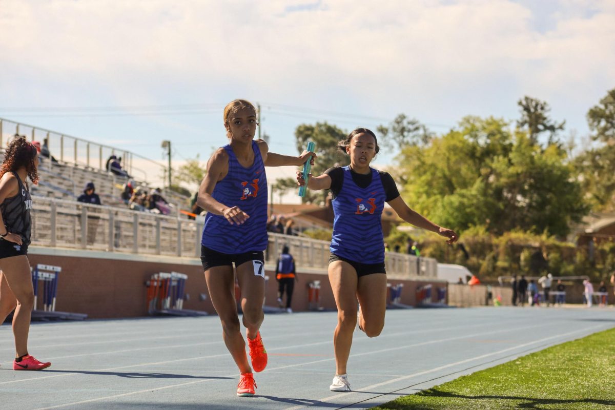 Freshman Tiana Ellis hands off the baton to senior Janiyah Cosby.