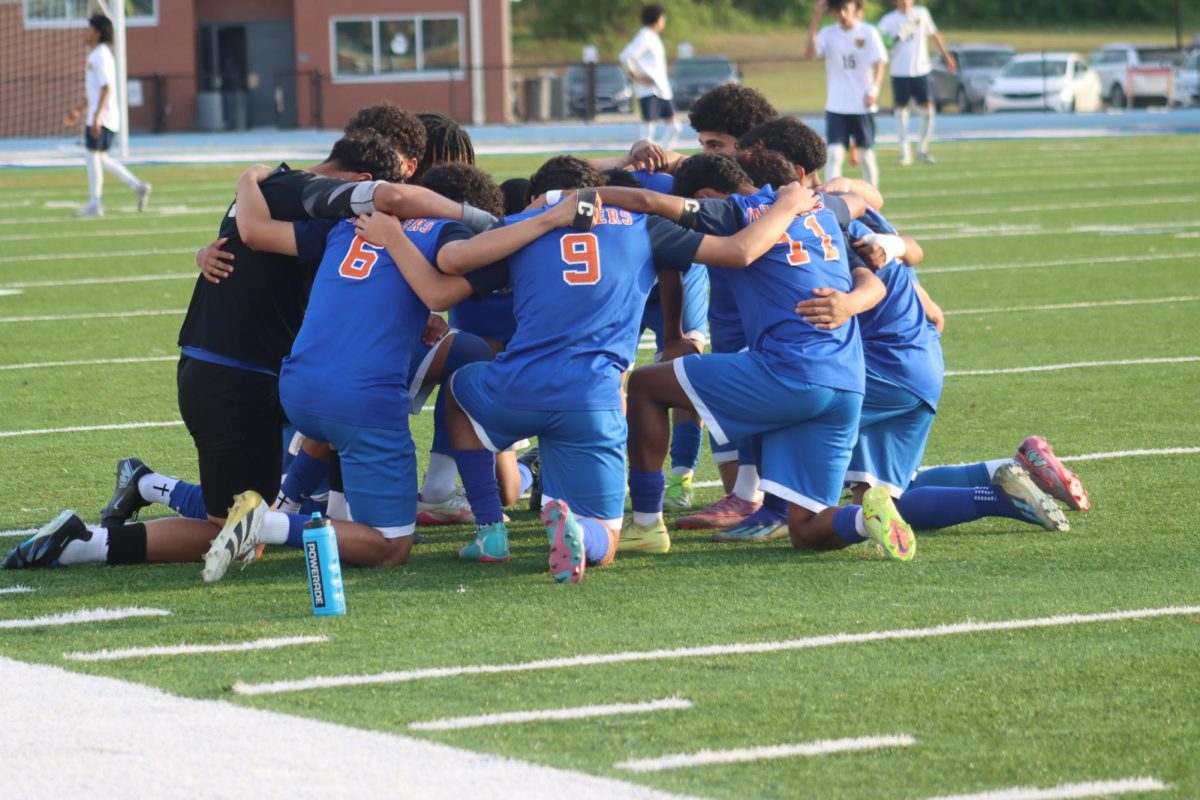 The boys varsity team prays before the game start 