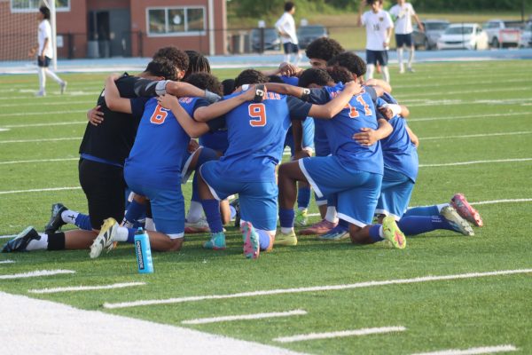 The boys varsity team prays before the game start 