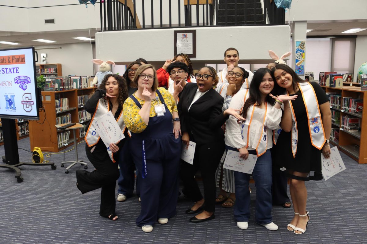 AVID teacher MaryAnn S-Wood and the AVID seniors pose for a silly photo. 
